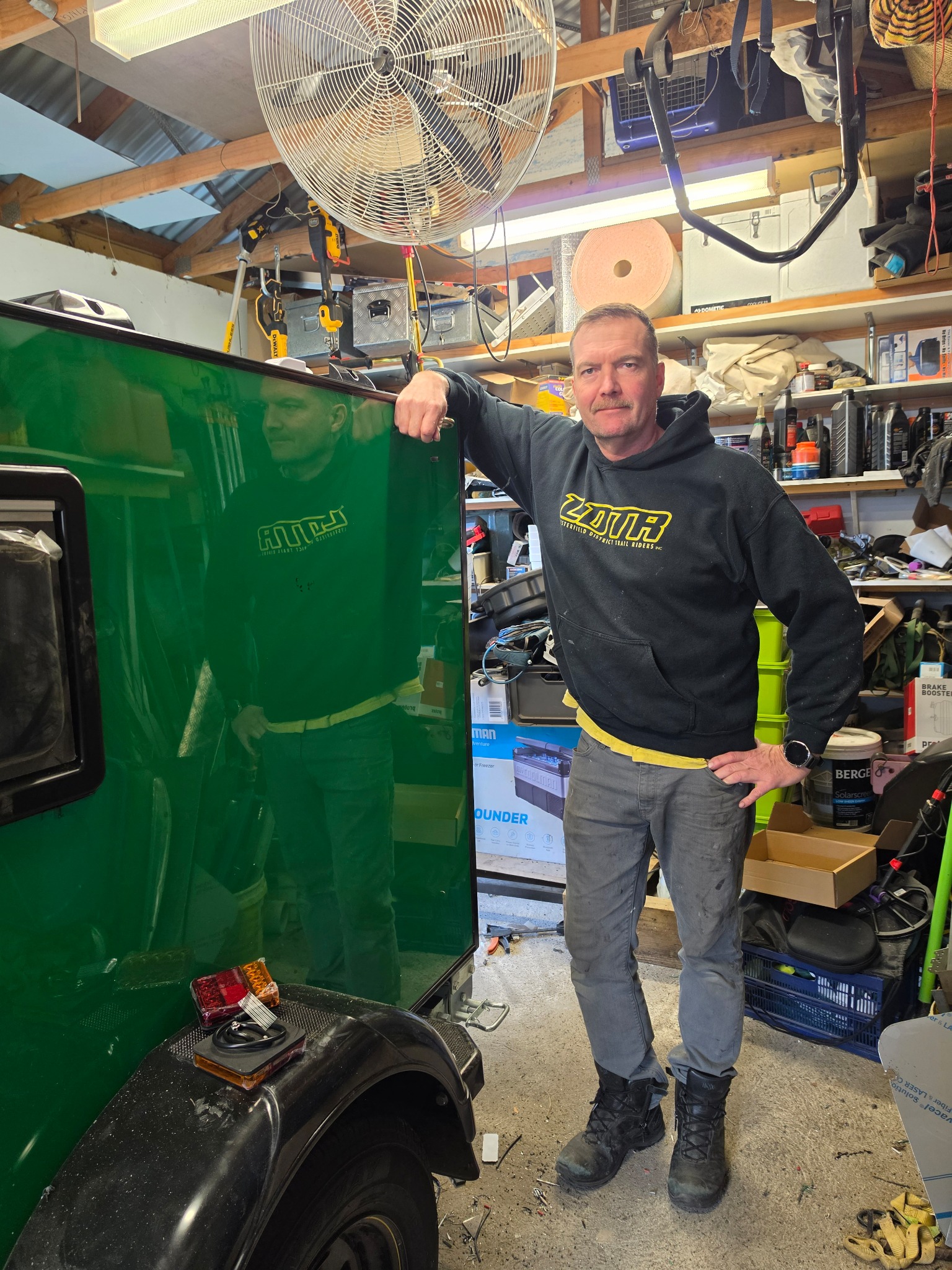 Derek standing beside a Mini Camper under construction in his workshop
